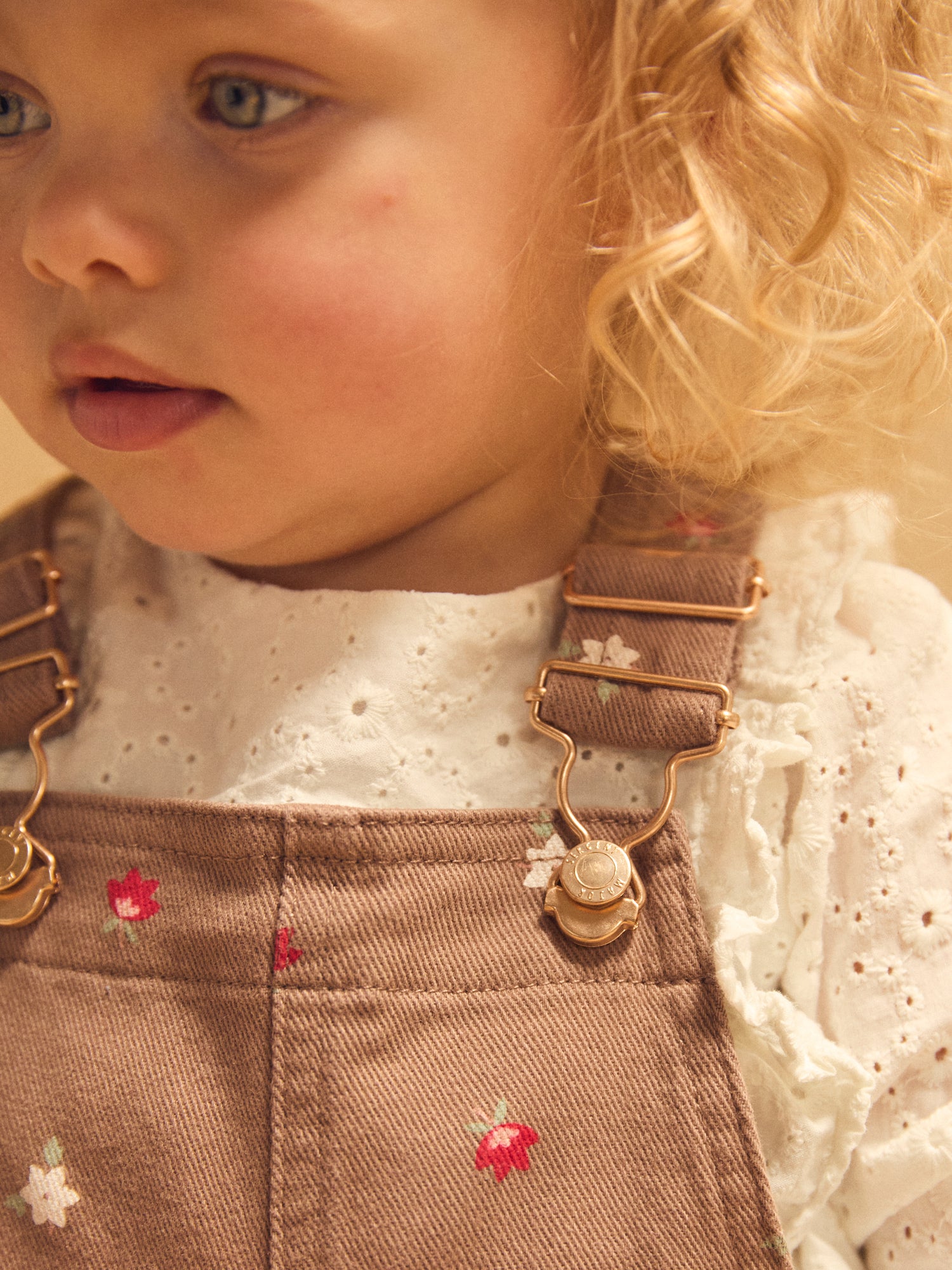 Kurze braune Latzhose mit Blumenmuster für Mädchen
