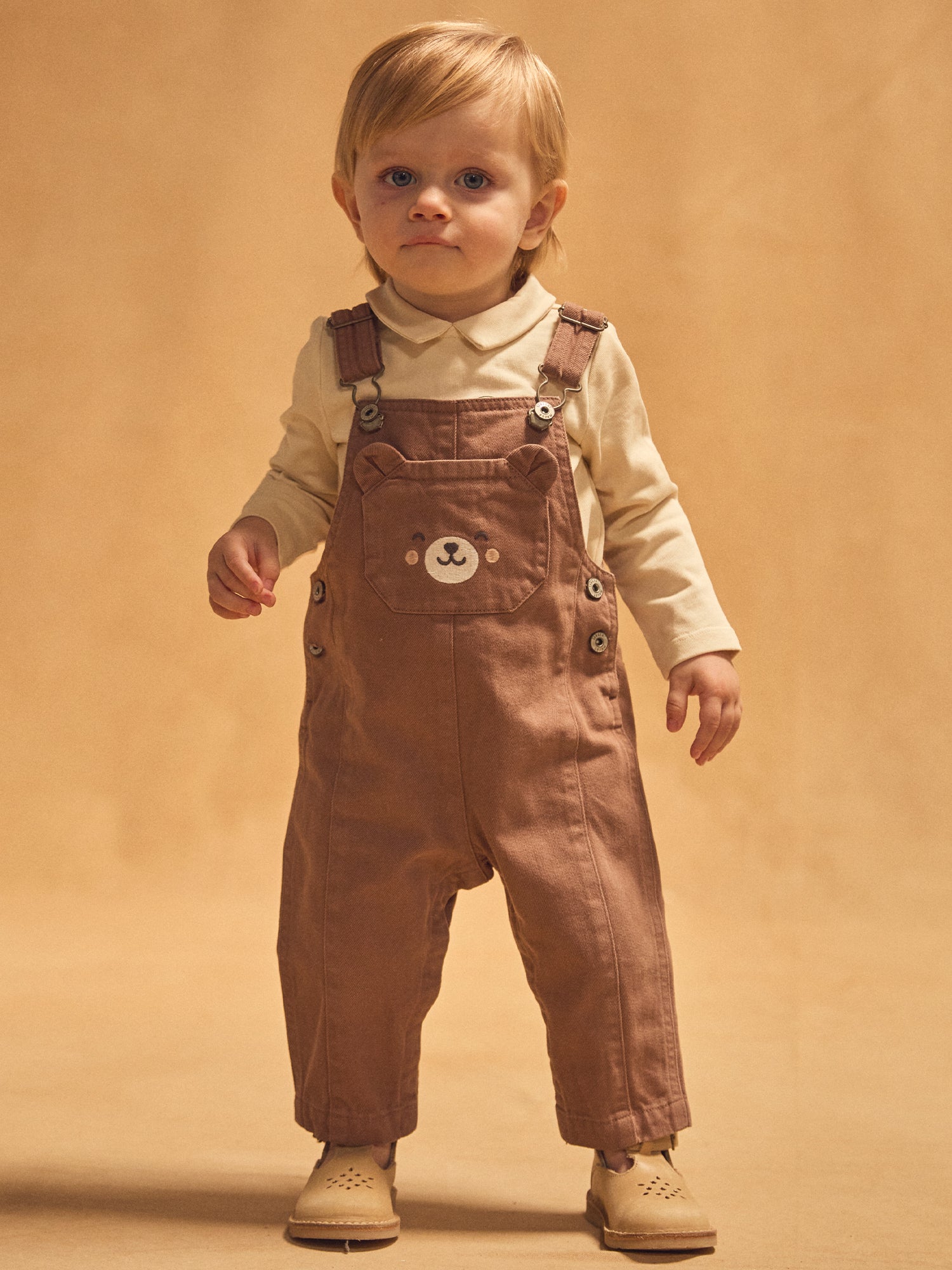 Braune Latzhose mit Baby-Bär-Tasche